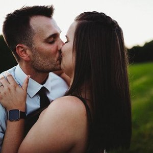A couple kissing outdoors at sunset
