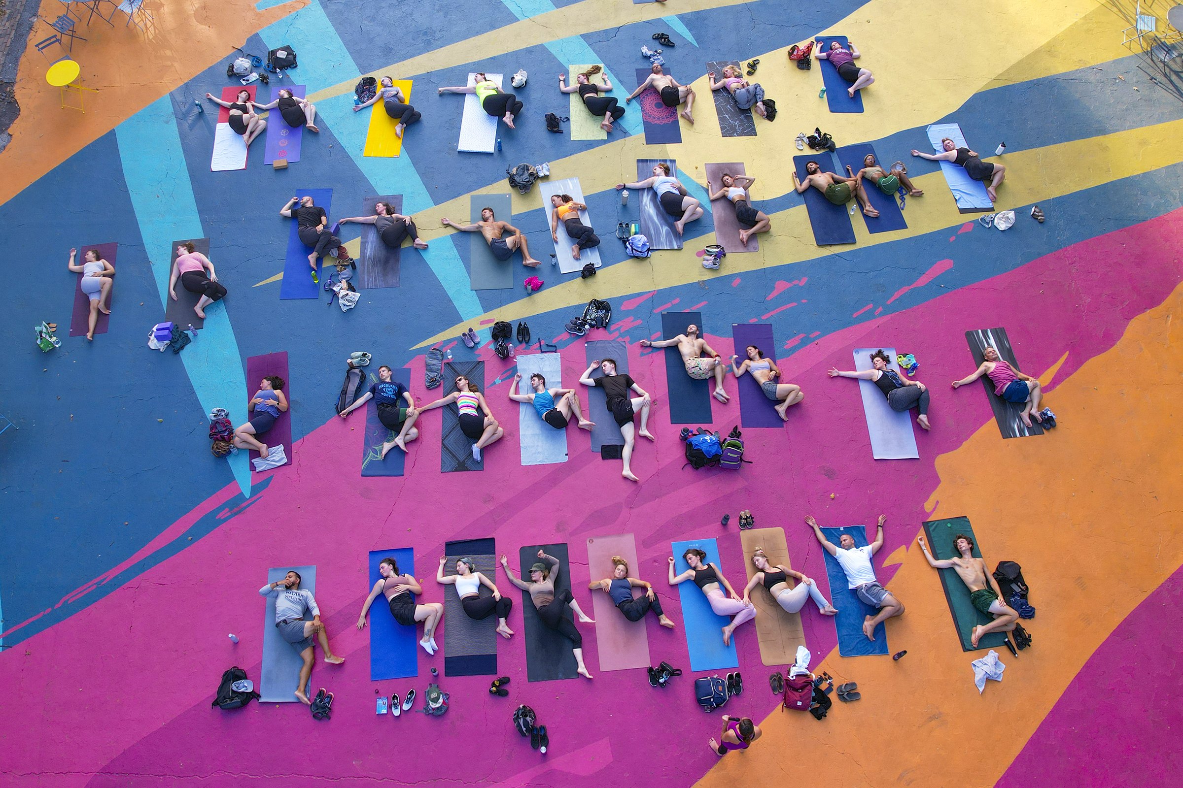  Participants relax and catch their breath after a yoga class at the Oval in Philadelphia on Wednesday evening, July 13, 2022. 