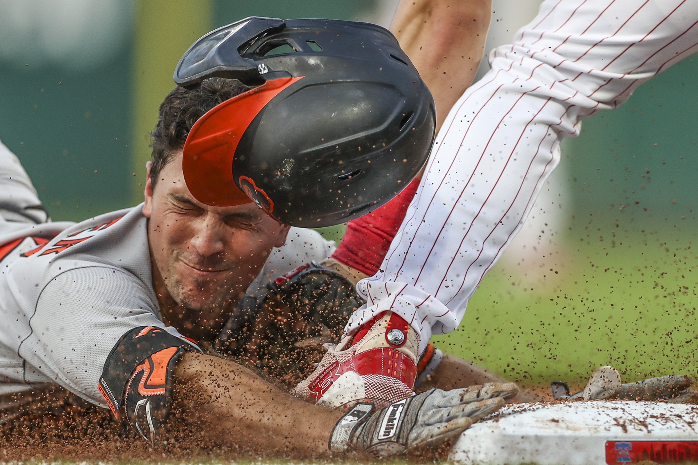  Baltimore Orioles second baseman Adam Frazier loses his helmet as he is tagged out at third base in the third inning of a game against the Philadelphia Phillies at Citizens Bank Park in Philadelphia on  July 25, 2023. 