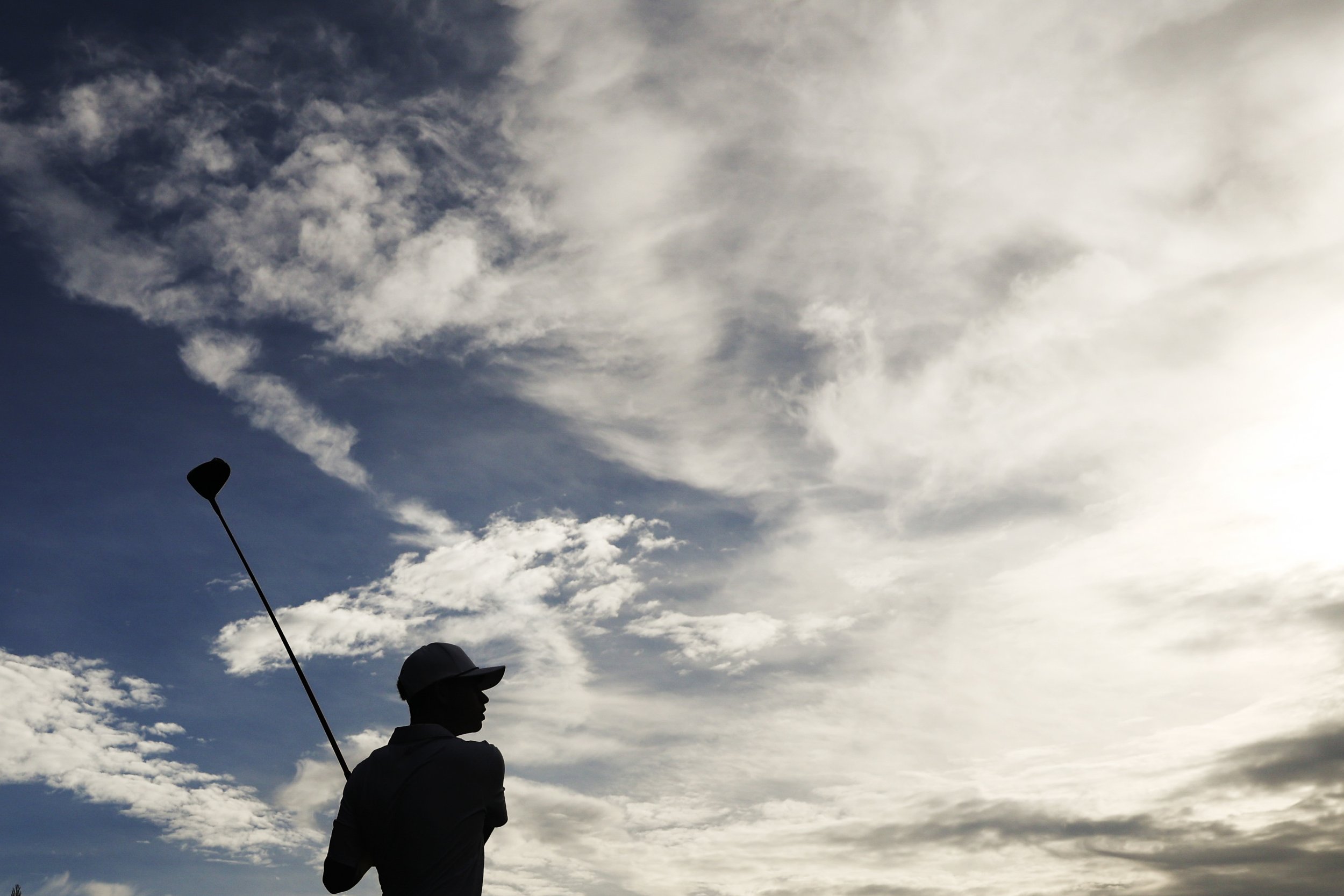  Jonah Benson is silhouetted as he tees off during practice for Cold Spring Harbor high school varsity golf at Huntington Country Club on Tuesday, Oct. 7, 2025.    