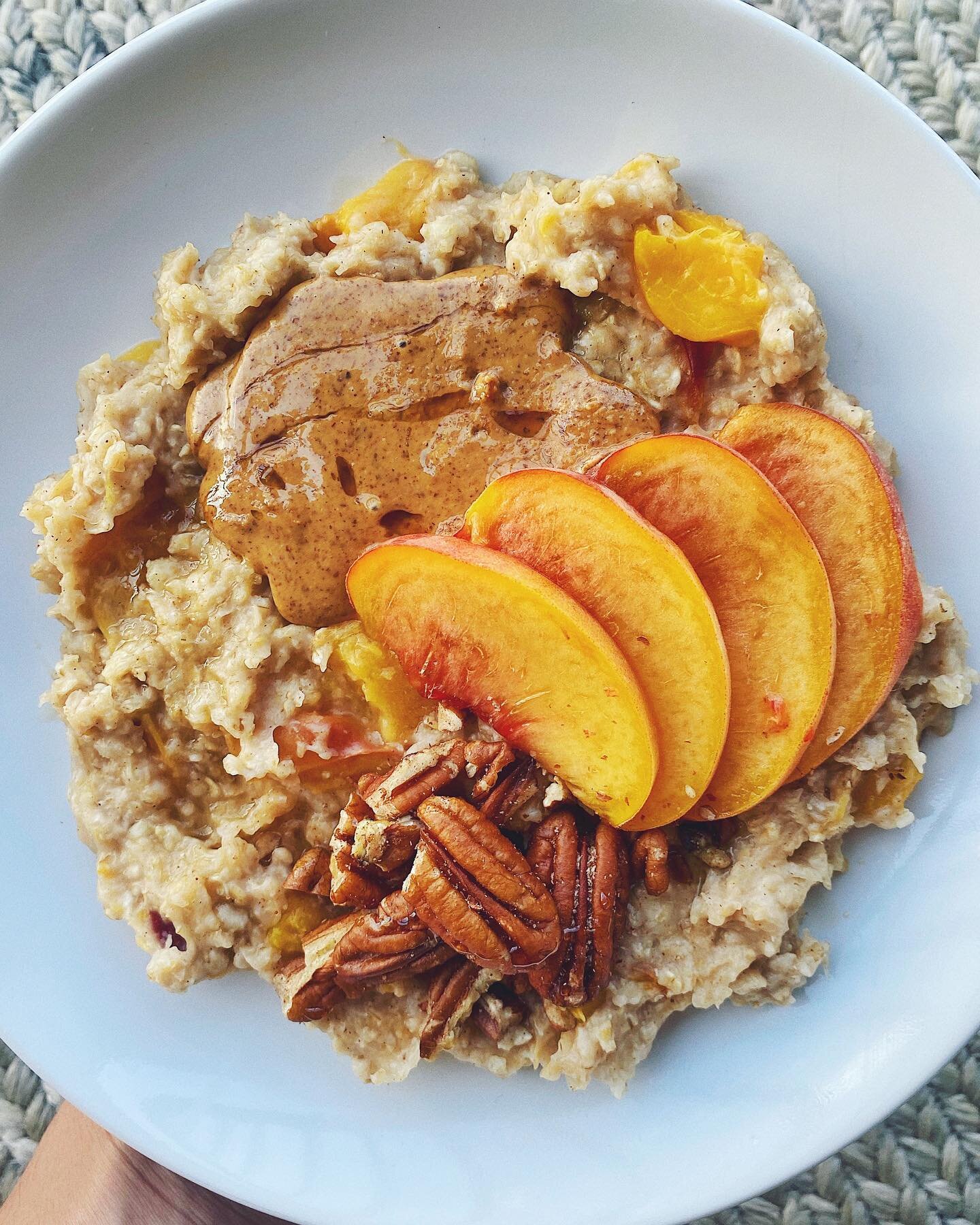 Excited about fall but still missing peach season - especially this peach oatmeal with cinnamon, almond butter, pecans and maple syrup. 😌 I chopped up half the peach and cooked it into the oatmeal, then sliced the other half and put it on top.
.
As 