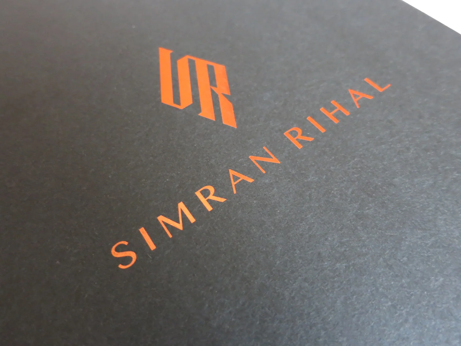 Rose gold foil logo on black paper