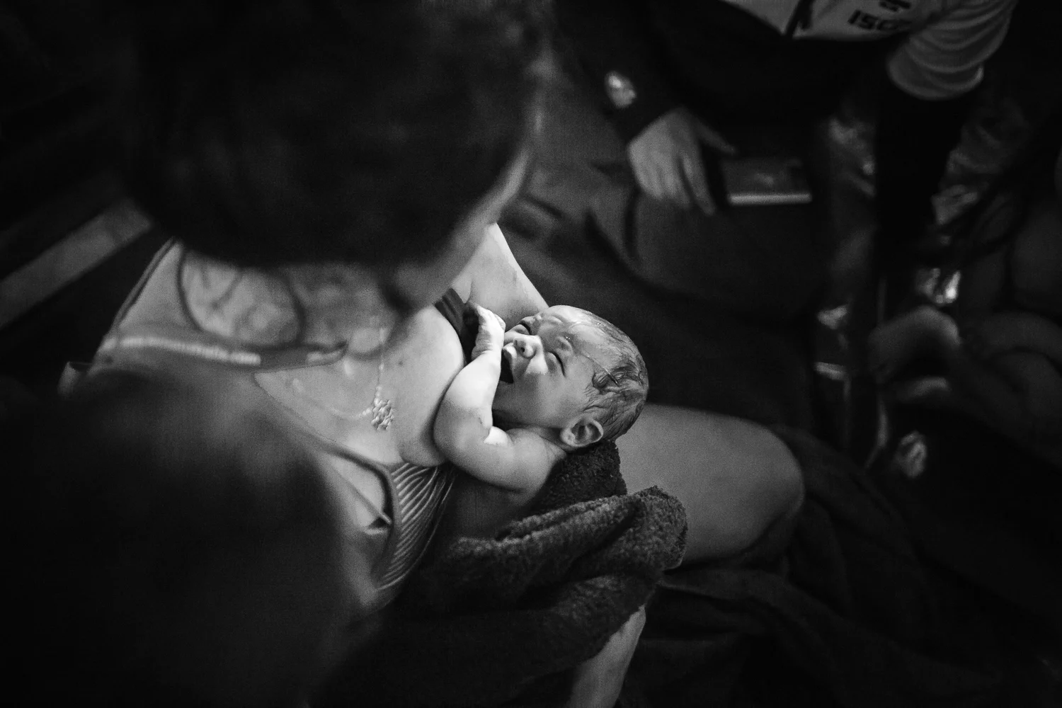 Newborn baby looking up at mother for the first time captured by Melbourne Birth Photographer, A Grateful Heart.
