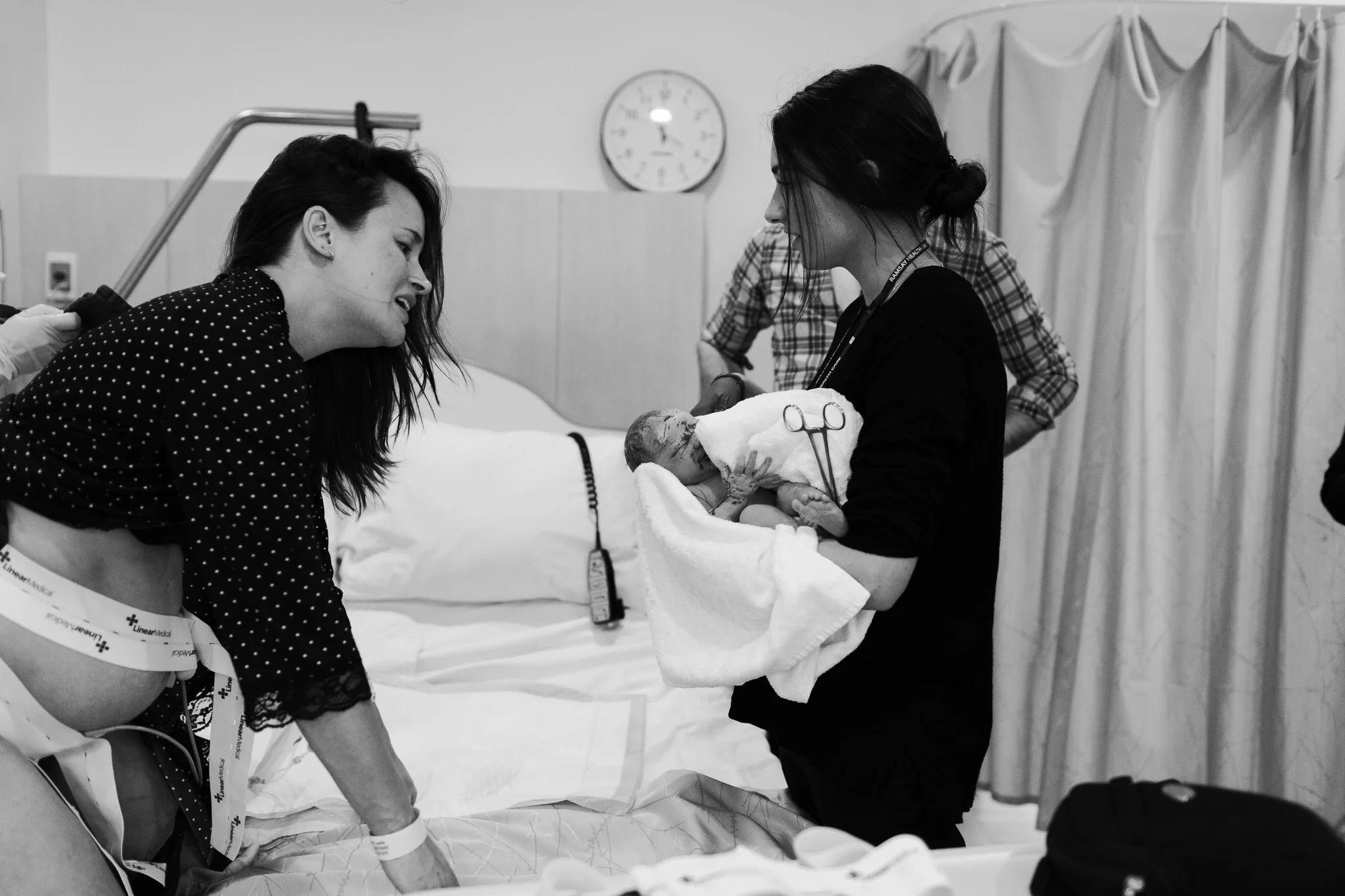 Love at first sight. Mother looking at newborn for the first time after fast birth at melbourne hospital as captured by melbourne birth photographer.