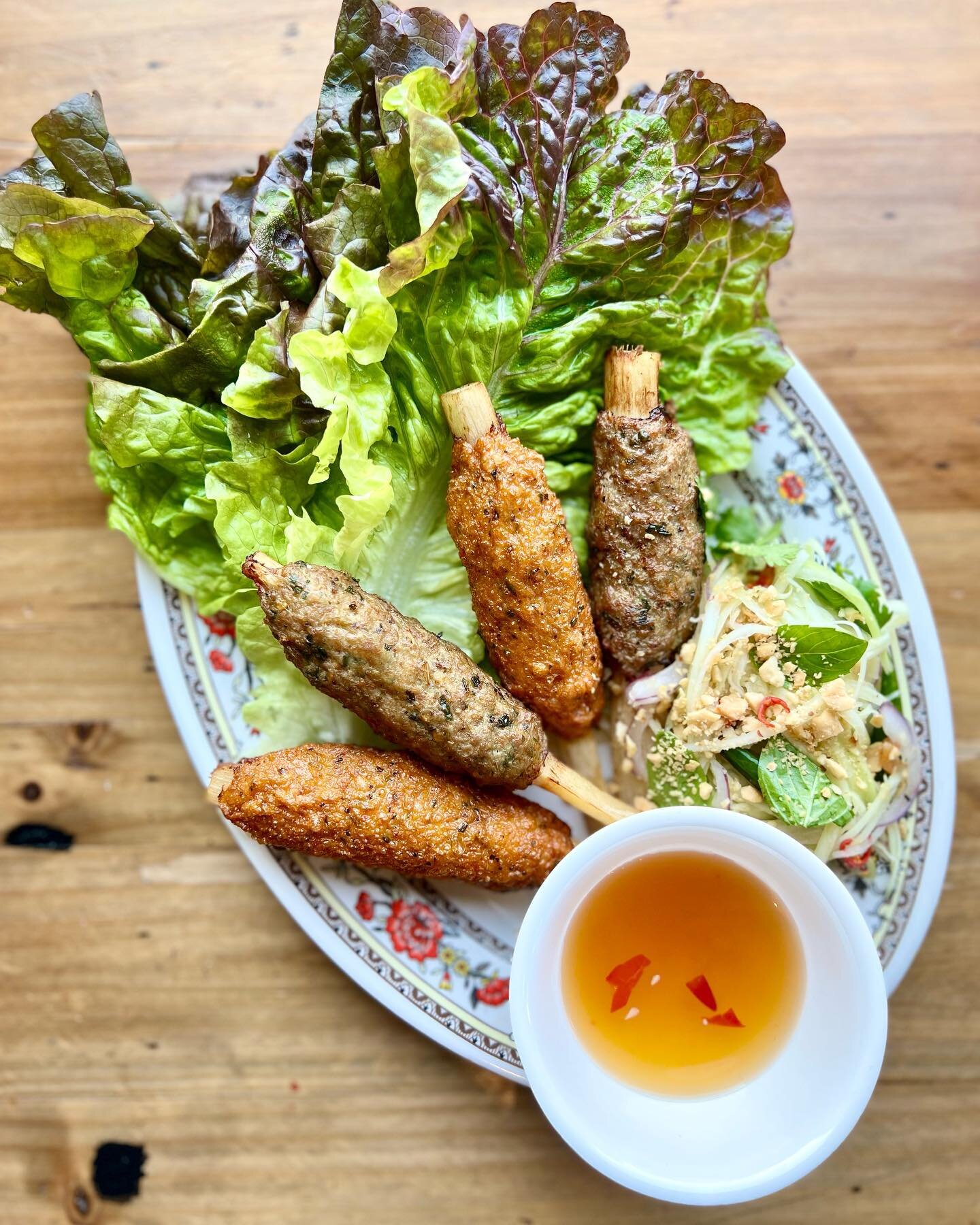THAI SUGARCANE SKEWERS: two Sai Oua Thai sausage skewers &amp; two Tod Mun red curry fish cake wrapped around sugarcane skewers, served with green papaya salad, lettuce for wrapping &amp; nuoc cham! This is a Thai &amp; Vietnamese mashup are the skew