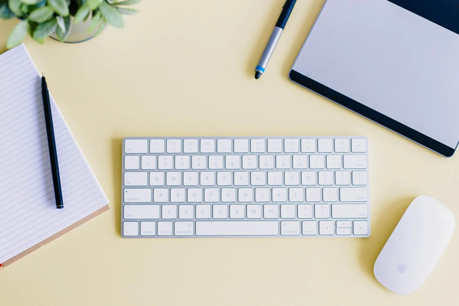 A desk with a keyboard and journal out, waiting for website copy to be written.