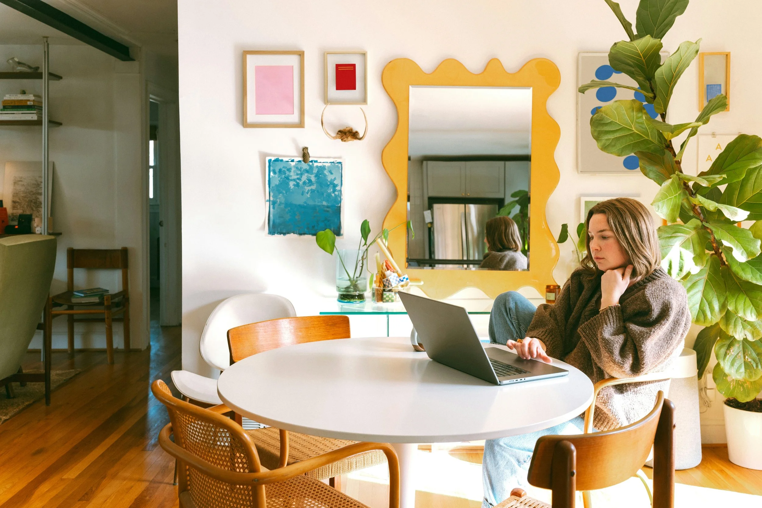 woman sitting at a table building a website on her computer using one of Look & Feels Squarespace templates