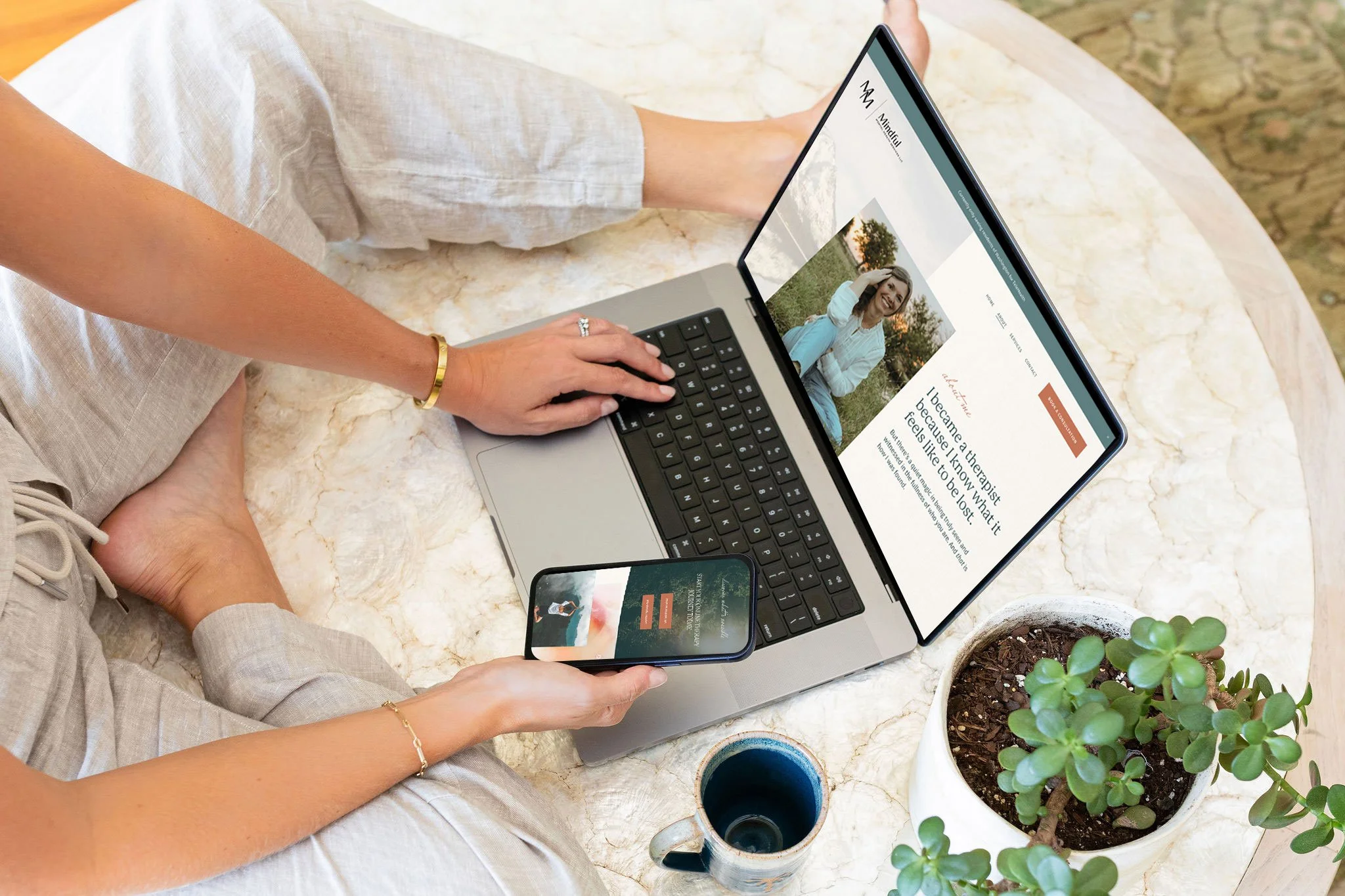 A woman sits on a marble table viewing a custom therapy website