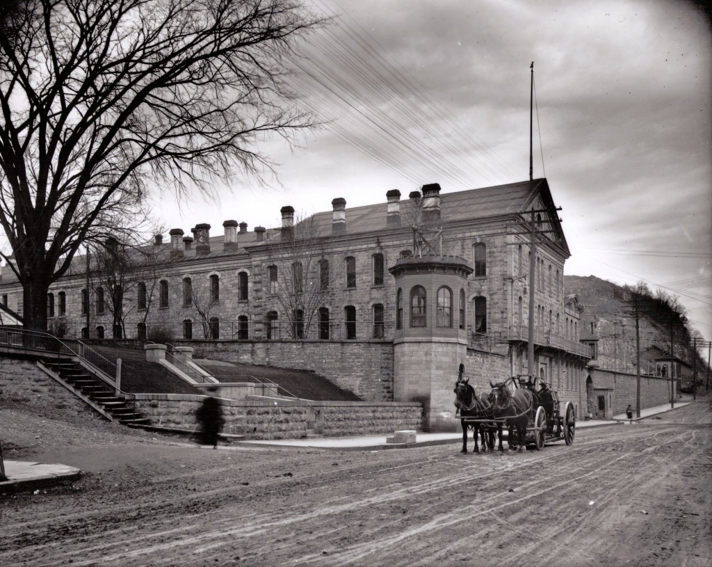 This is a view of the Territorial Prison in 1907. The wagons are hauling two tractor wheels from the foundry. The view is looking north on Main Street. Photo credit is Mr. John Runk, courtesy of The Stillwater Public Library, John Runk Collection. Click or Tap on the photo to view a "Time-Tunnel" morph of this same location going from 1907 to 2016.