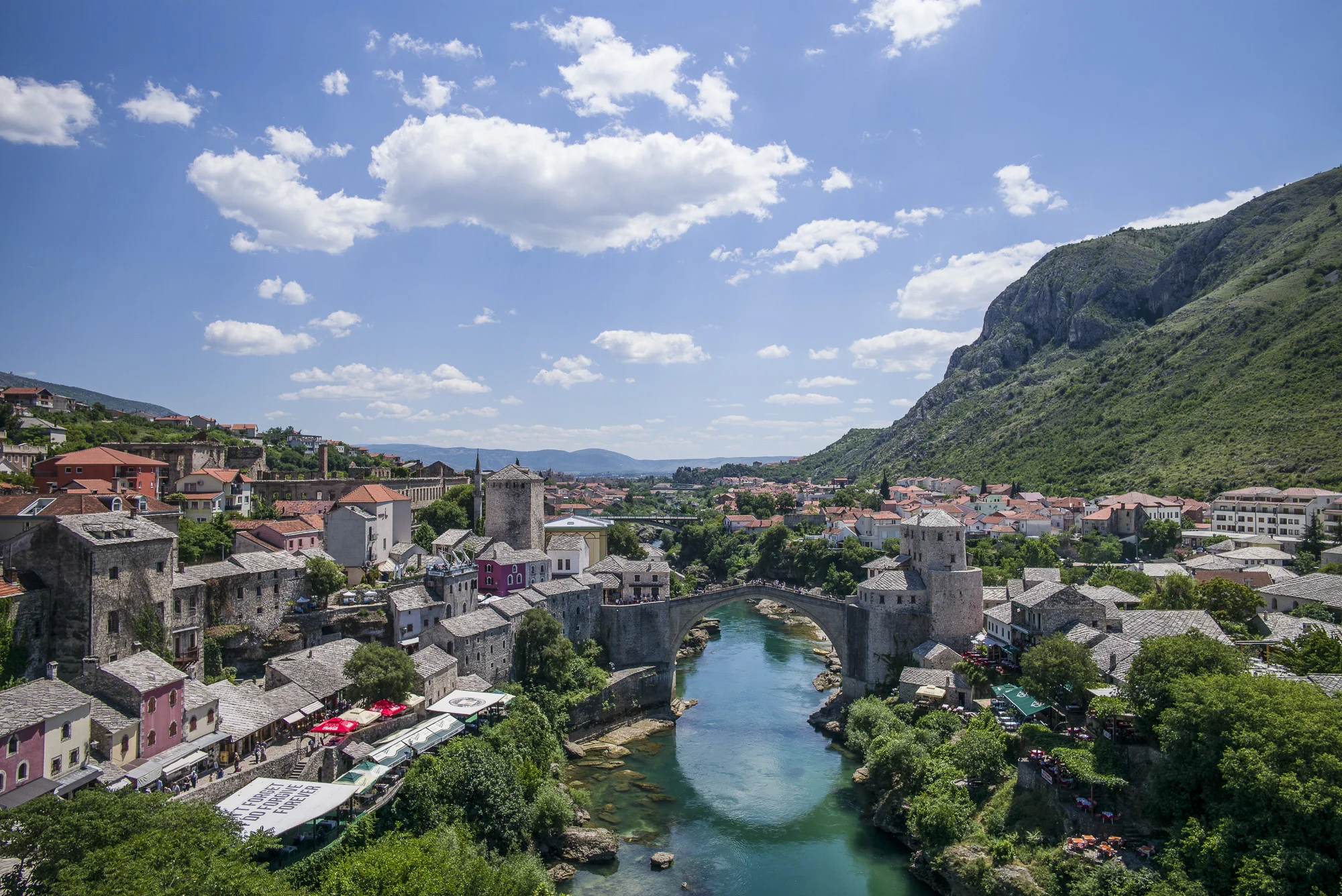 The Mostar bridge (Stari Most) over the Neretva River. Note the sun shade, " I DON"T FORGET, I DO FORGIVE, FOREVER