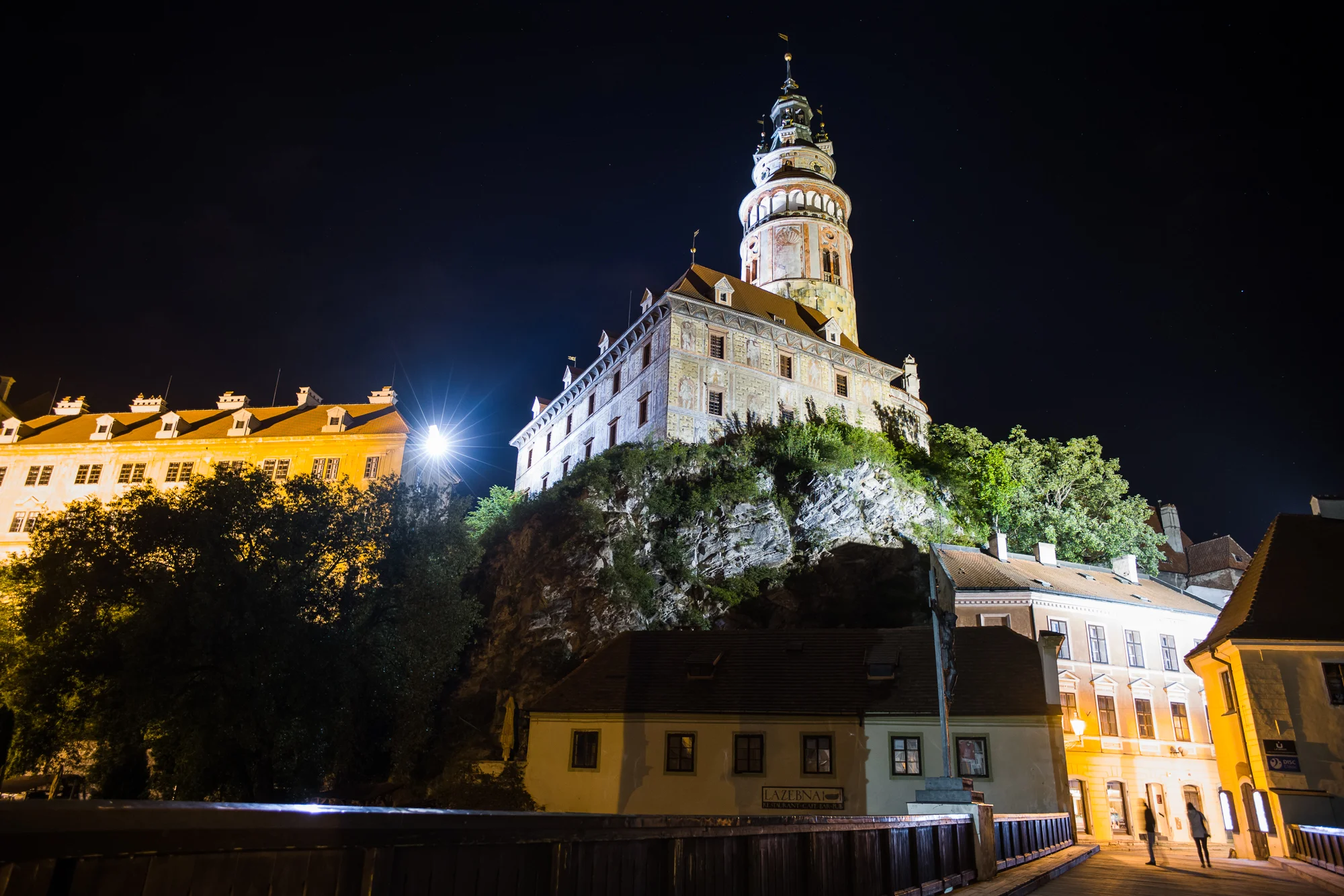 Česky Krumlov castle at night as seen from a bridge crossing the Vltava River in the old town