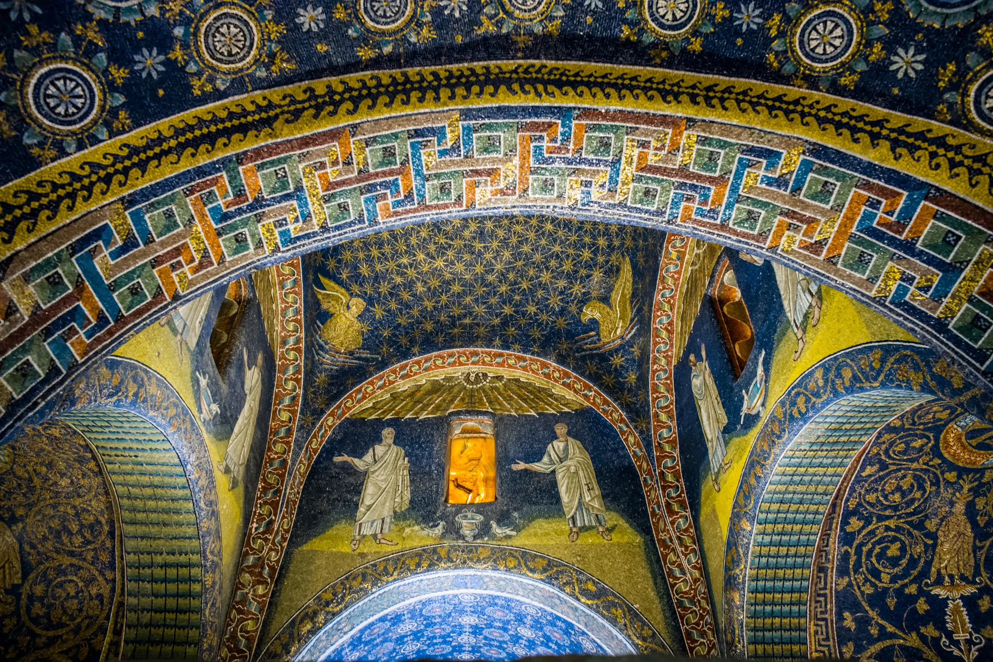 The Mosaics of the Mausoleum of Galla Placidia. The sun’s light shines through windows of cut stone.