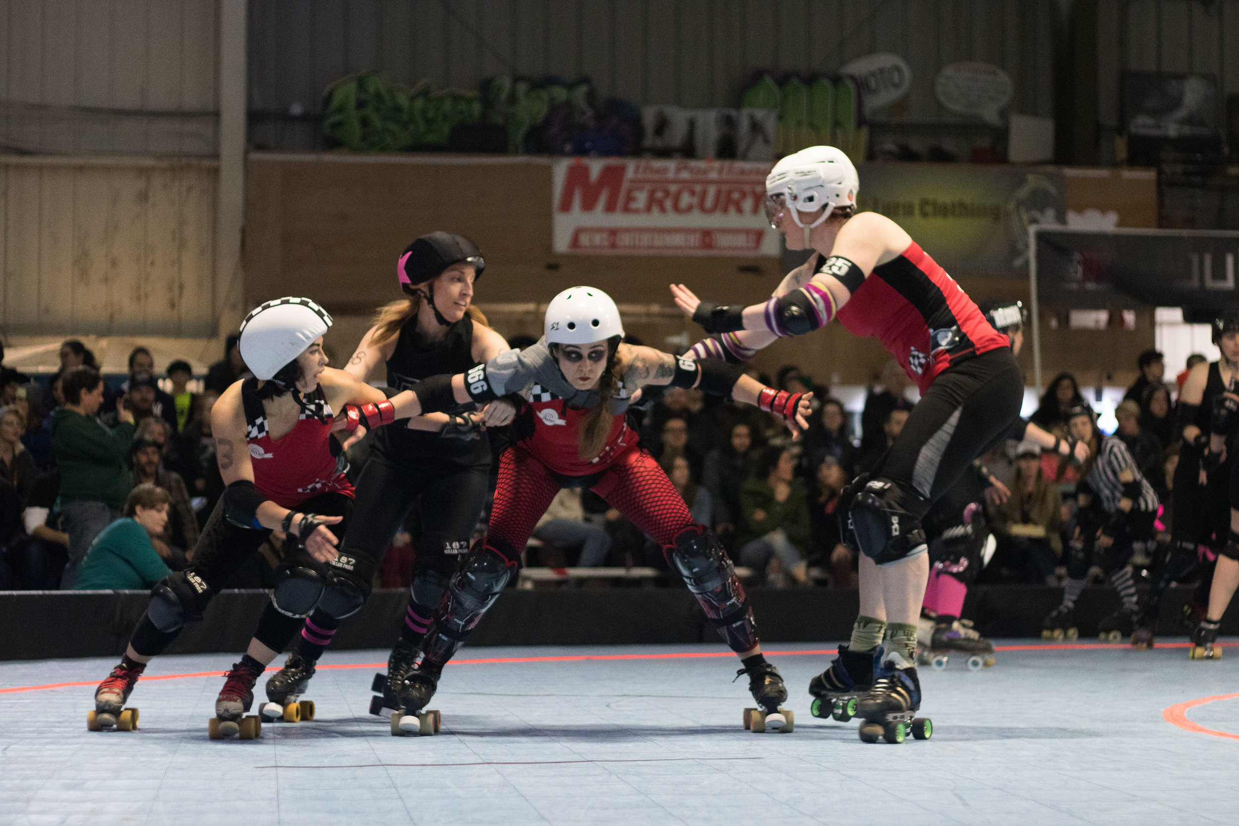 Smelter Skelter (center) and Break Neck Betties teammates block players from opposing team Guns N Rollers at Oaks Park in Portland, Ore., May 13, 2017. Guns N Rollers defeated the Break Neck Betties 226-222.