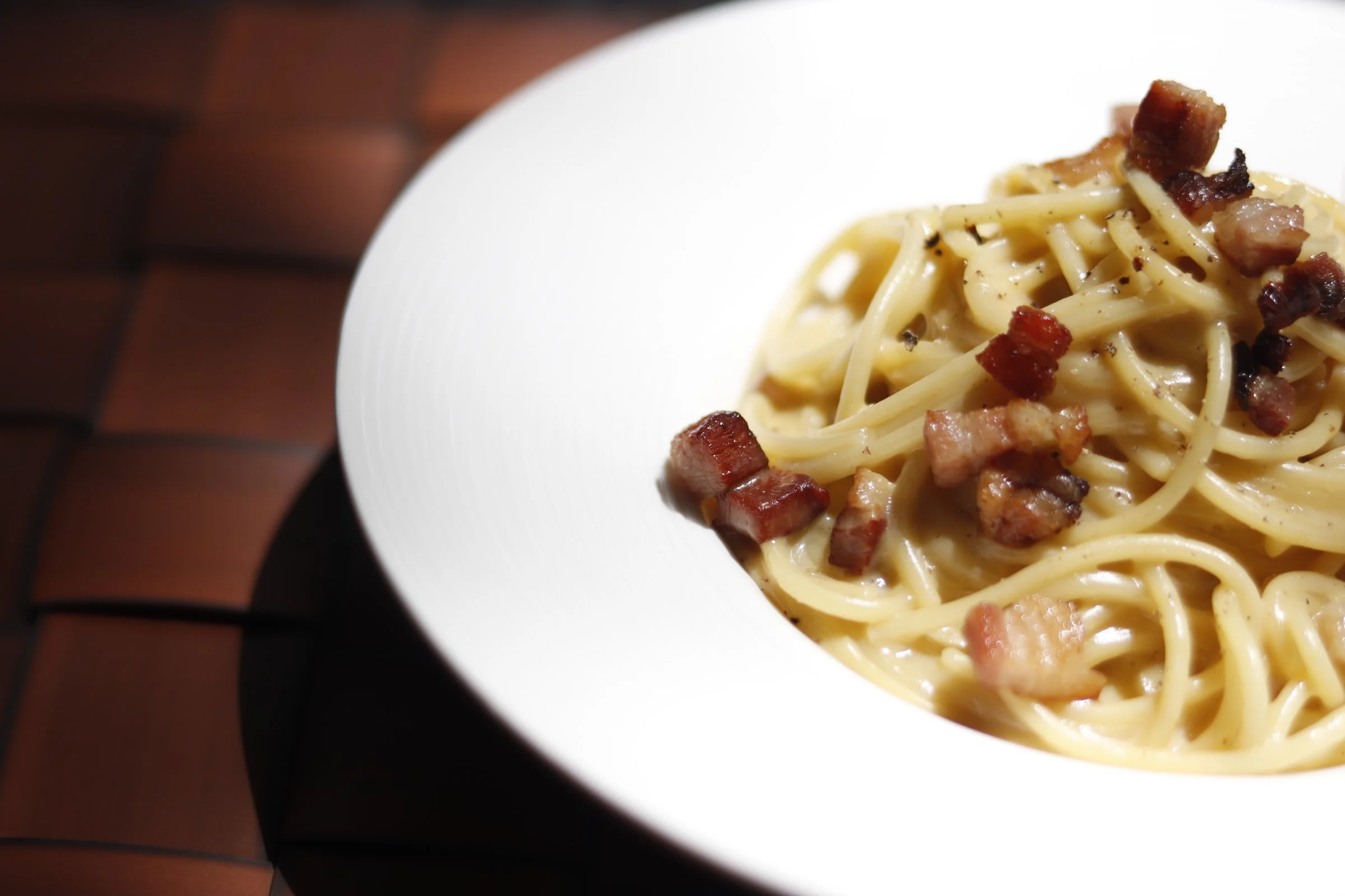 Spaghetti alla Carbonara is an Italian classic with freshly grated parmesan and egg yolk.  At Kermit, we top it with pancetta bits