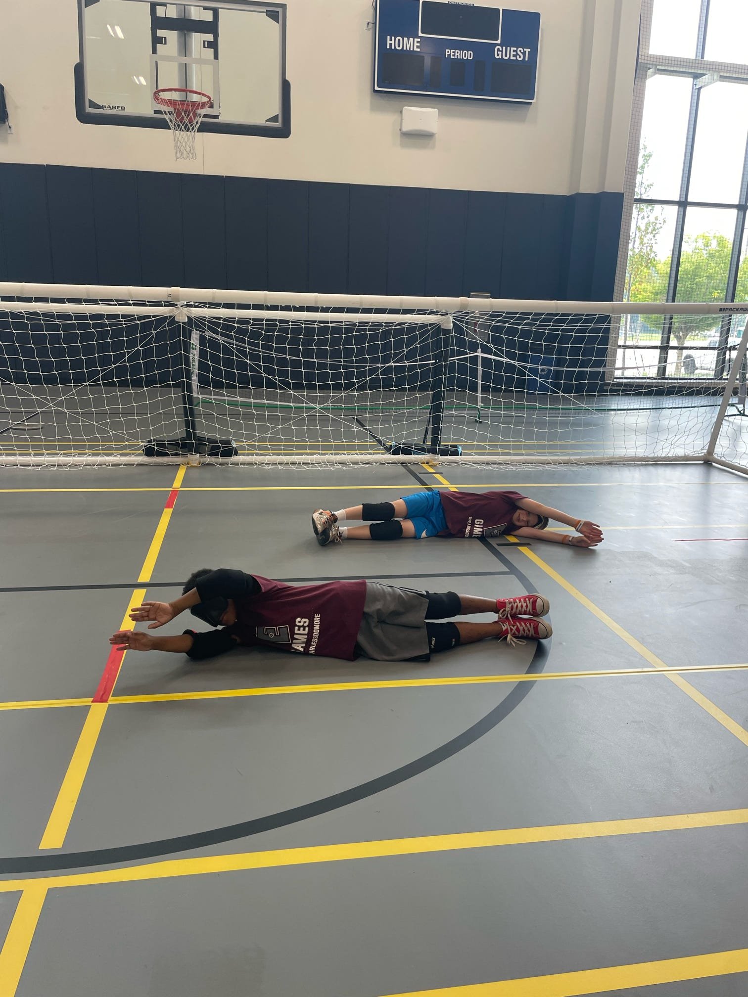  Two  athletes playing defense in a game of goalball 