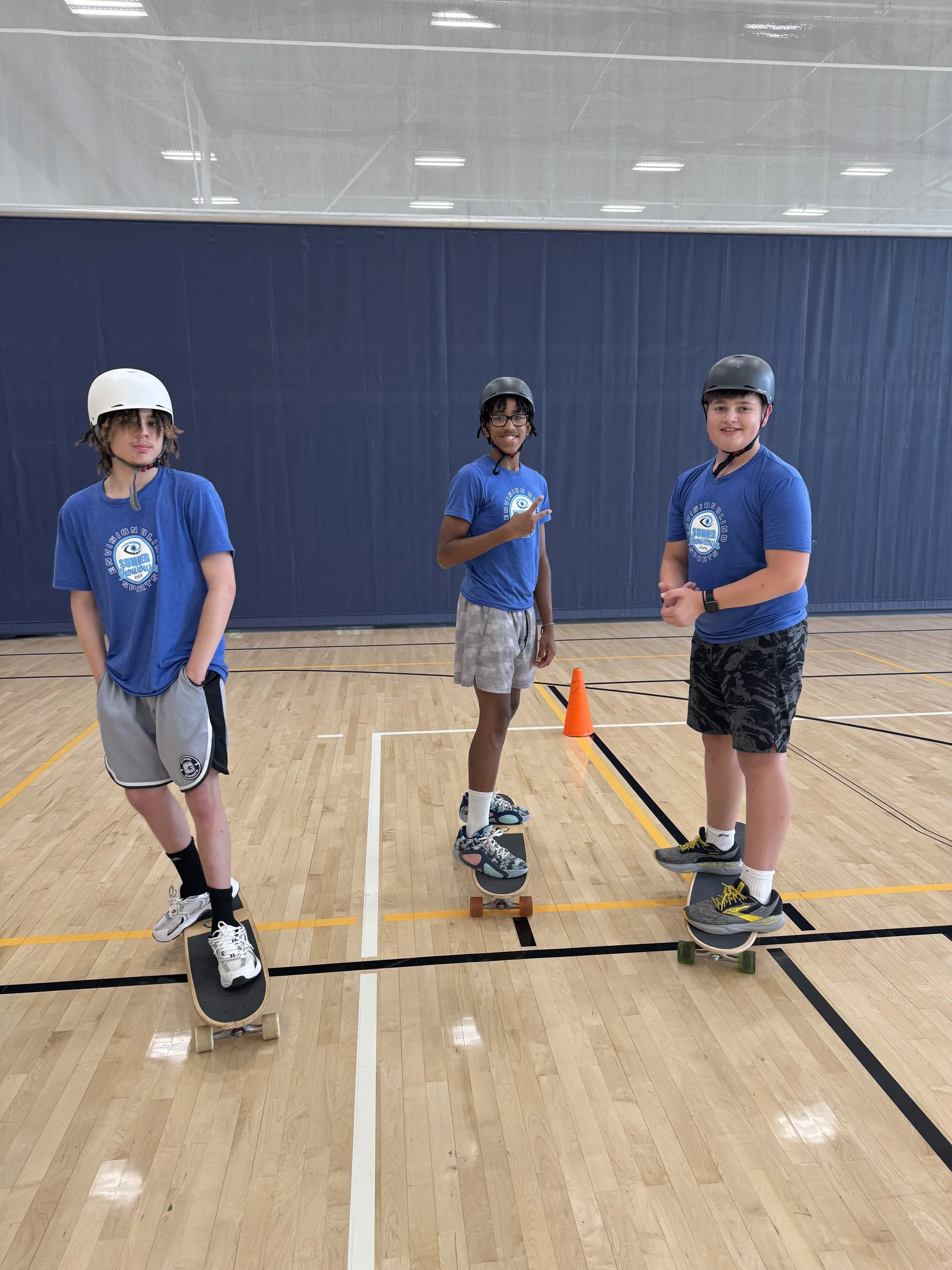 Three athletes balancing on the longboard skating towards the camera