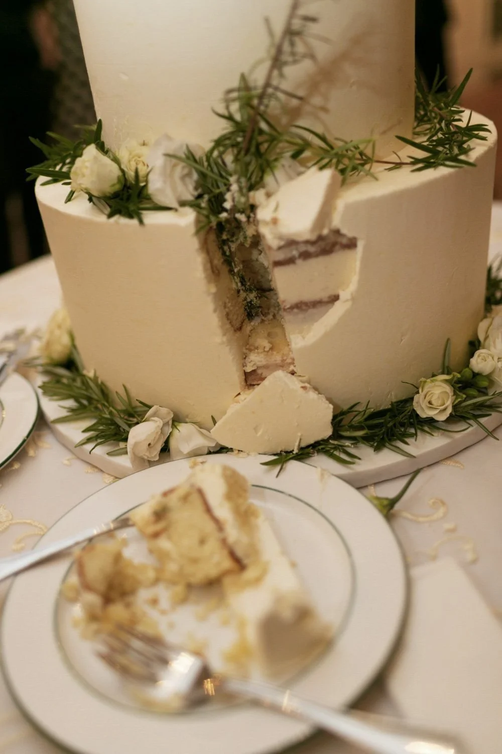 A slice of white wedding cake with creamy frosting, at The Meadow club of Southampton