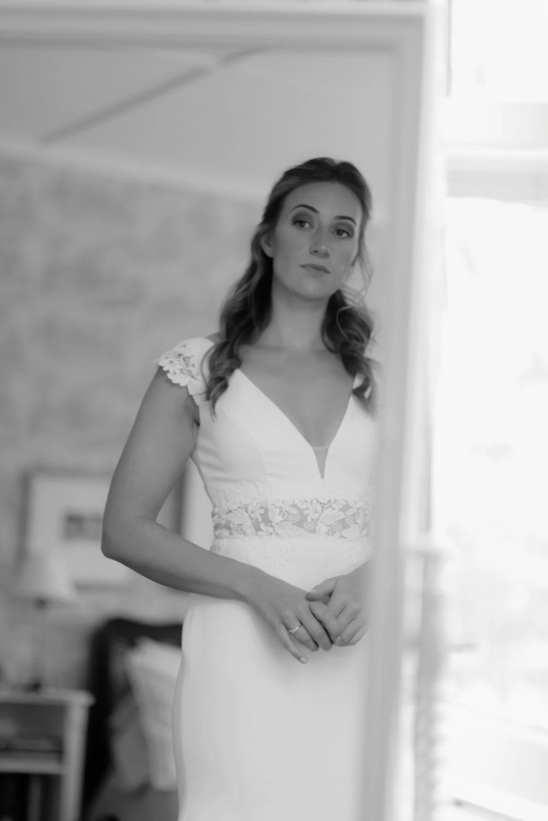 A woman in a wedding dress looking at herself in a mirror.