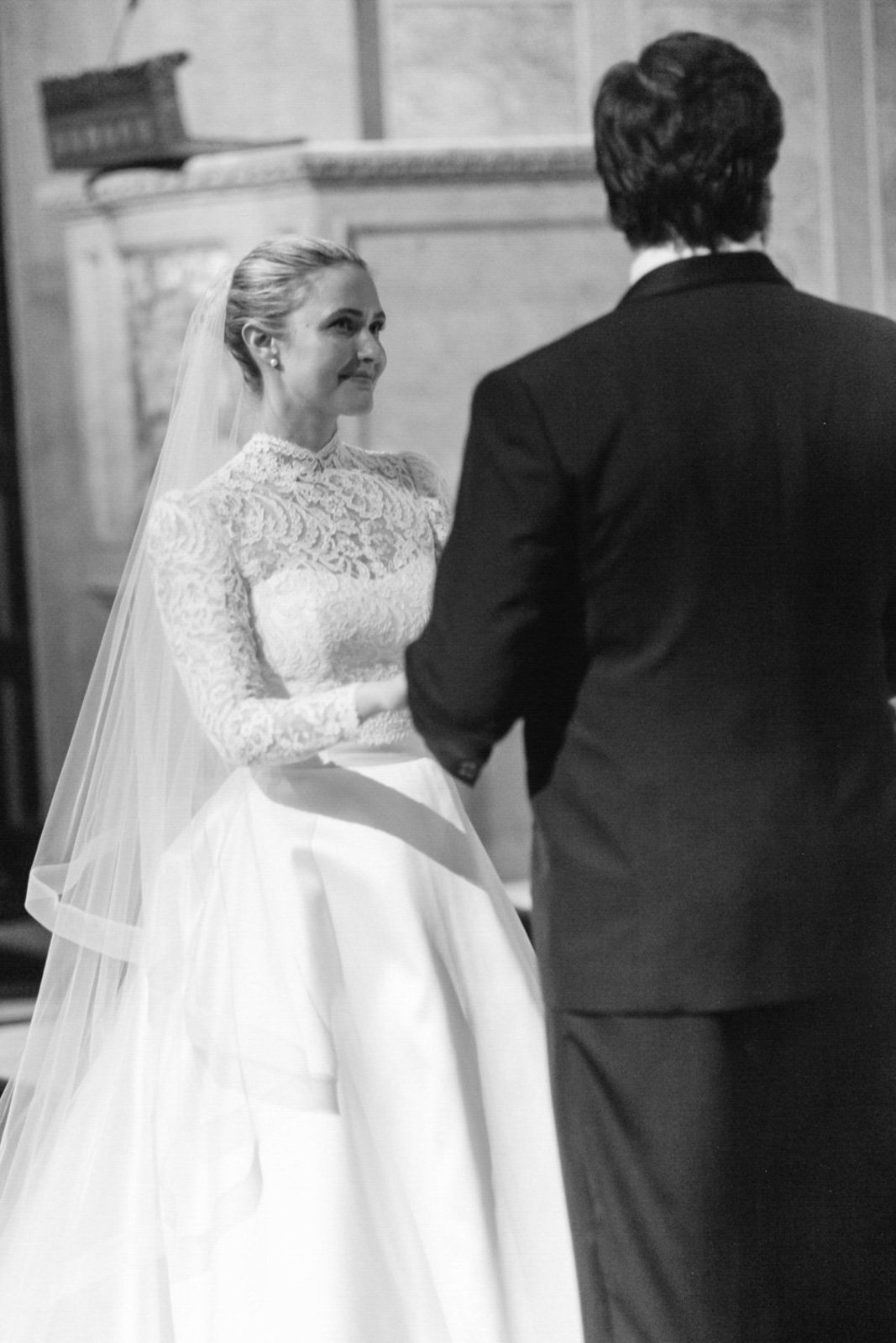 A bride and groom exchanging vows during their wedding ceremony inside a church.