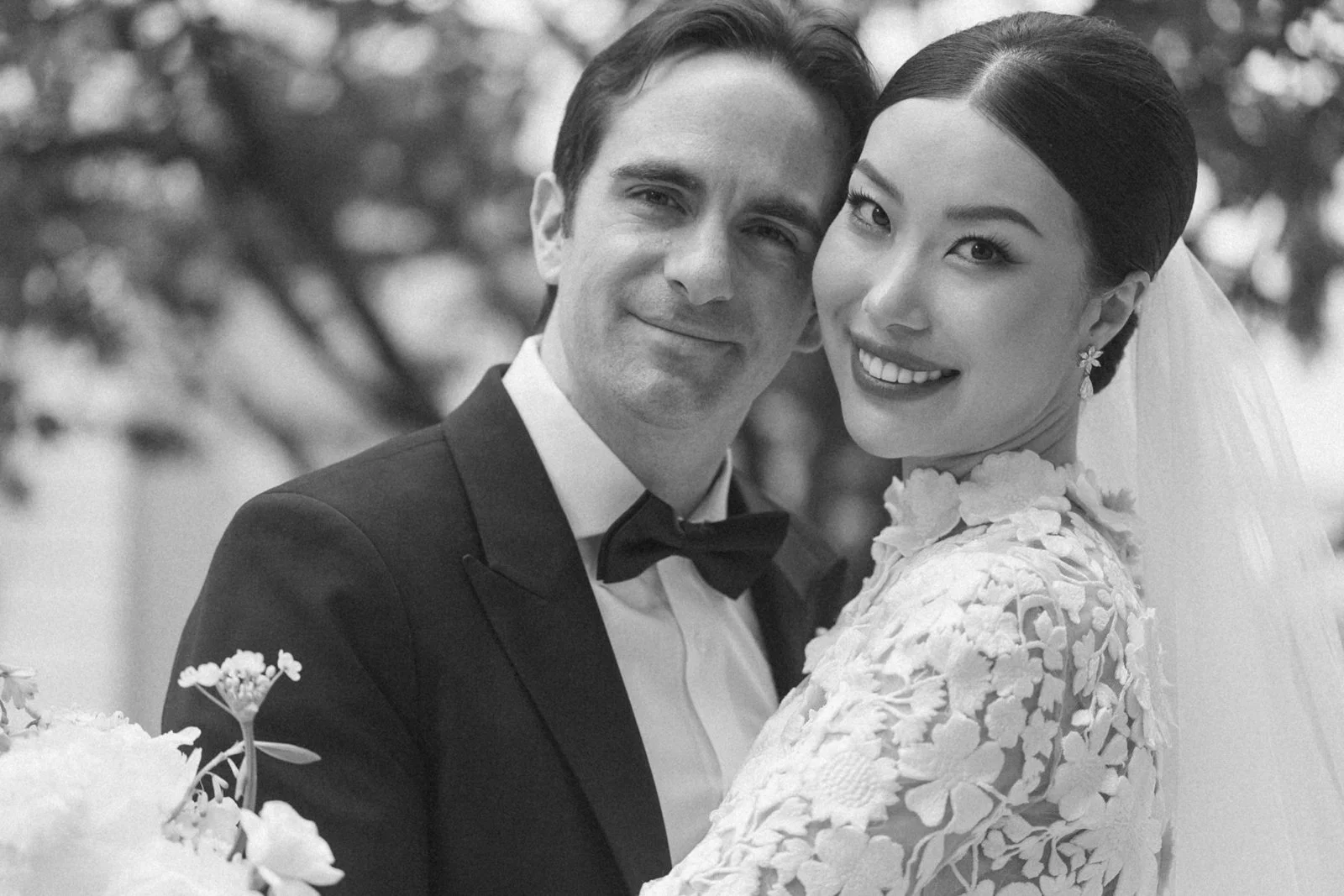 Black and white photo of a smiling bride and groom on their wedding day, close-up.