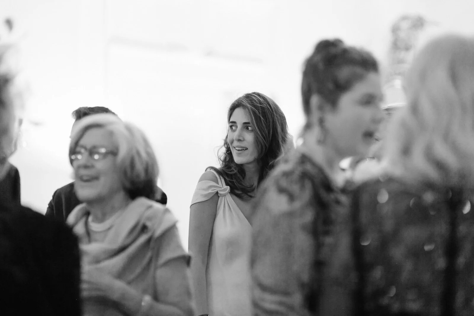 Group of women in a social setting, engaging in conversation and smiling.