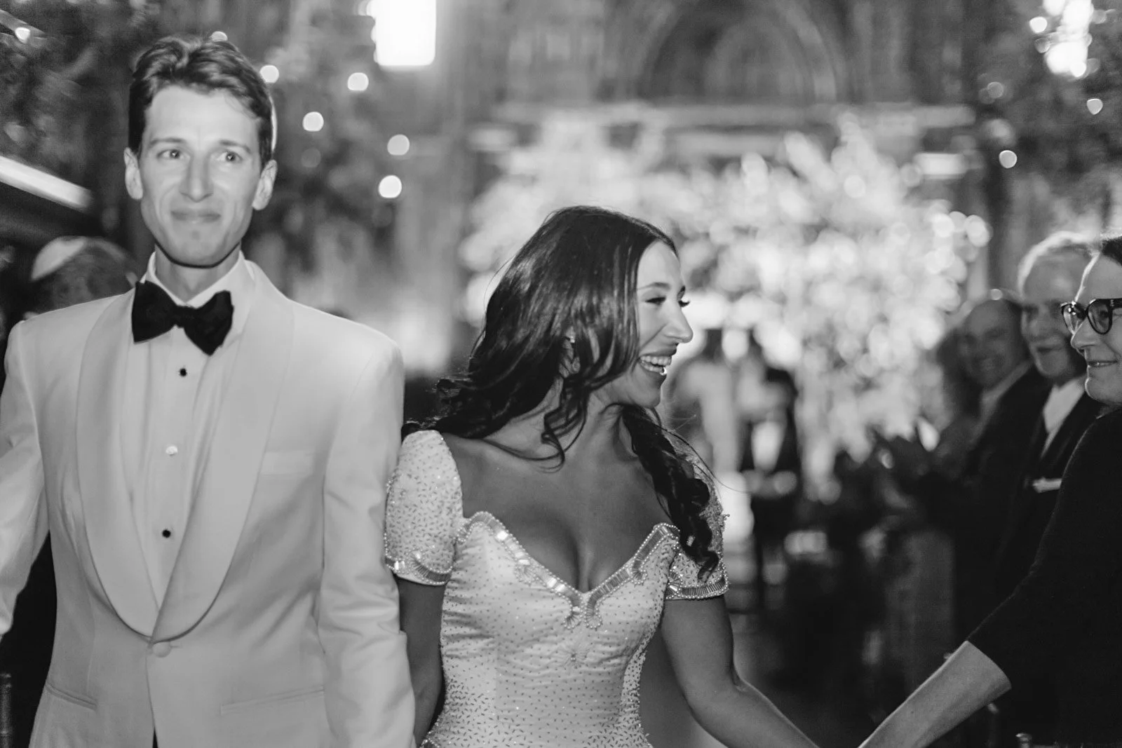 A wedding celebration with a bride and groom dancing, with several guests watching, in a decorated venue.