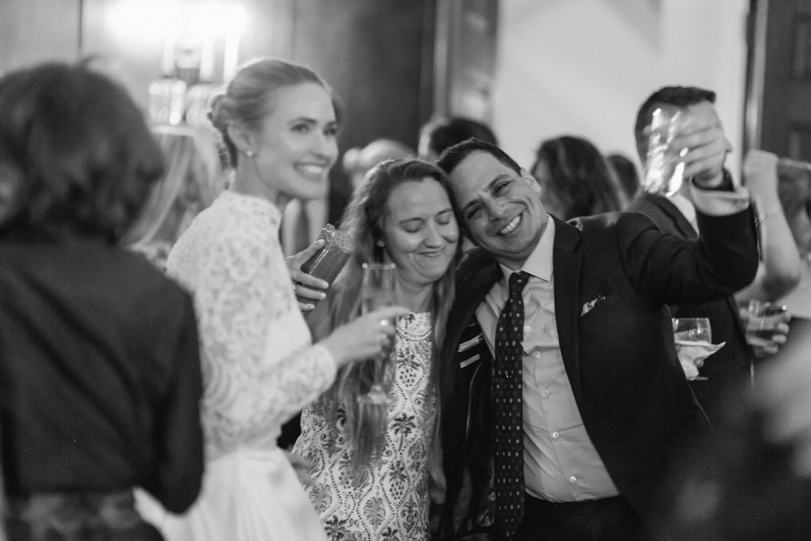 People at a celebration or party, smiling, holding drinks, in a social gathering.