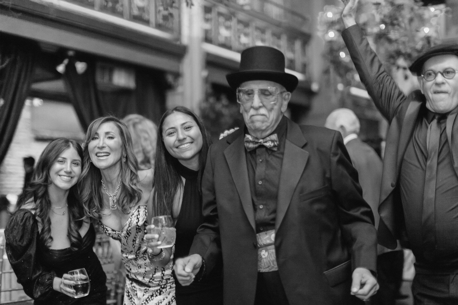 Group of people dressed in vintage or formal attire celebrating at an event