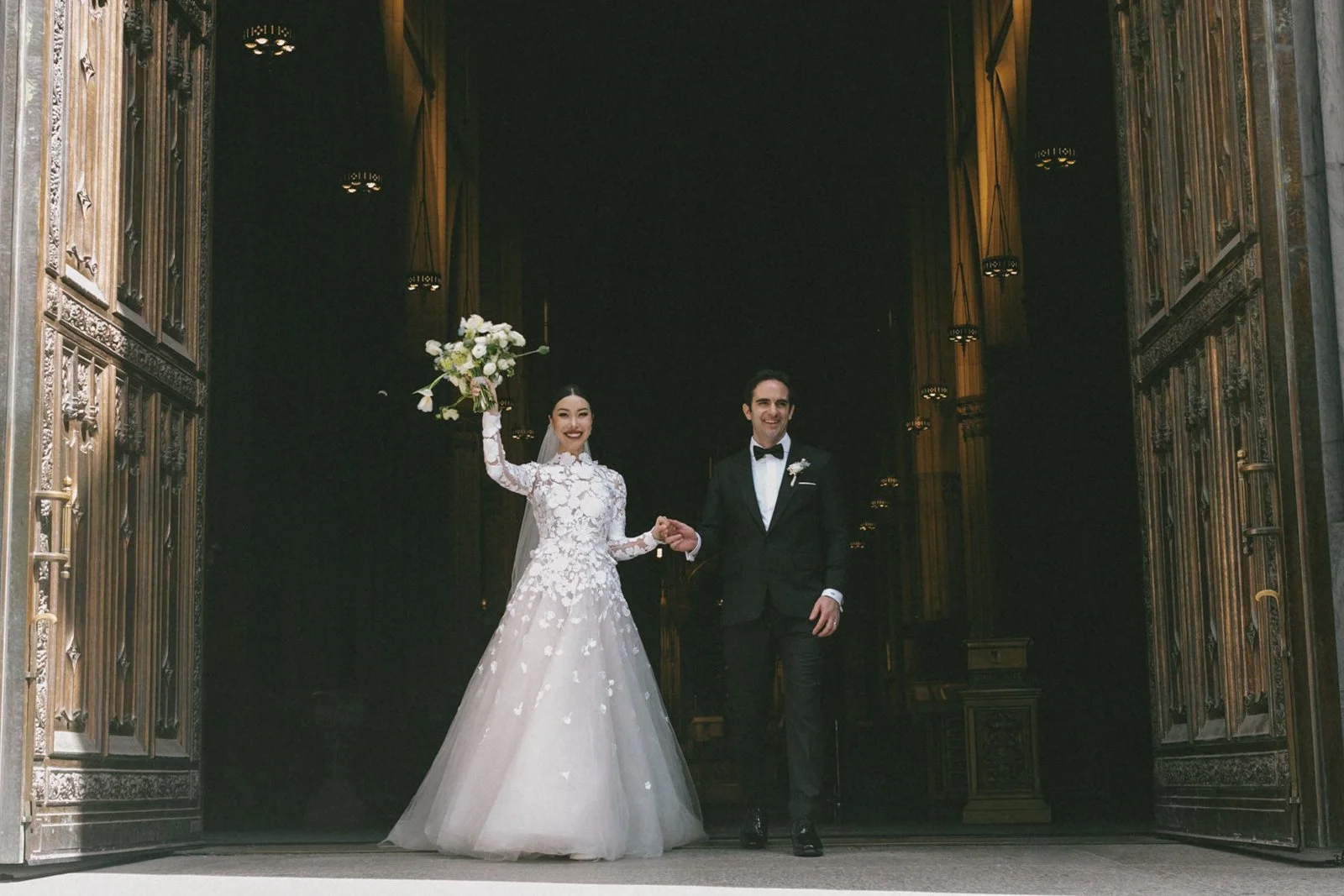 happy bride and groom holding hands and walking out of a church.