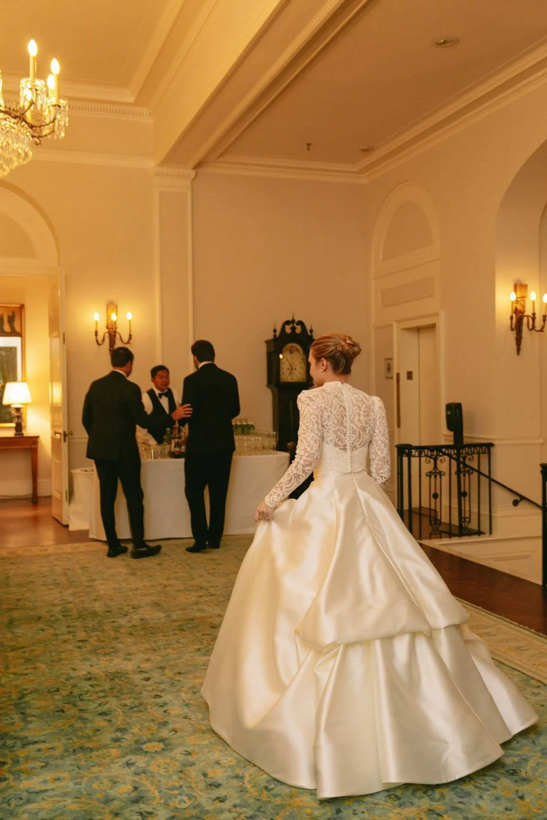 A bride in a white wedding gown standing in a luxurious, elegantly decorated room, at The Colony Club New York.