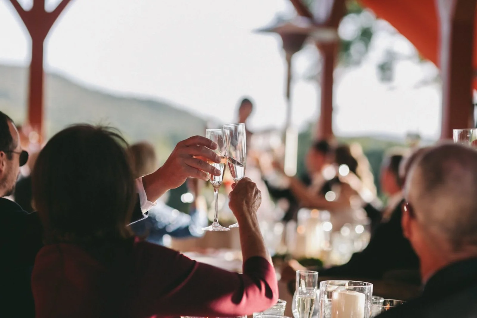People at a celebration or gathering toasting with champagne glasses in an outdoor setting.