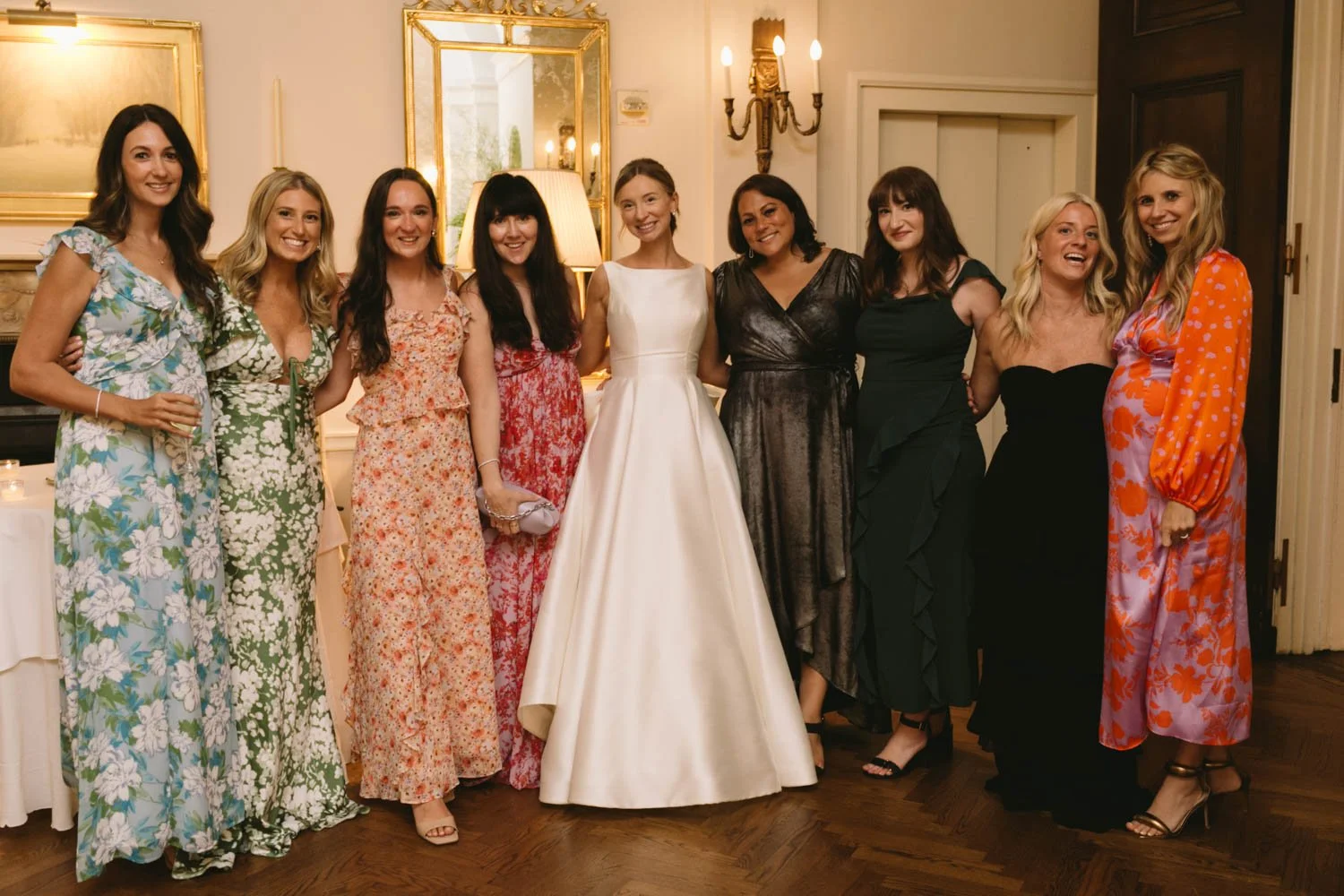 Group of women at a wedding, with the bride in a white gown at the center.