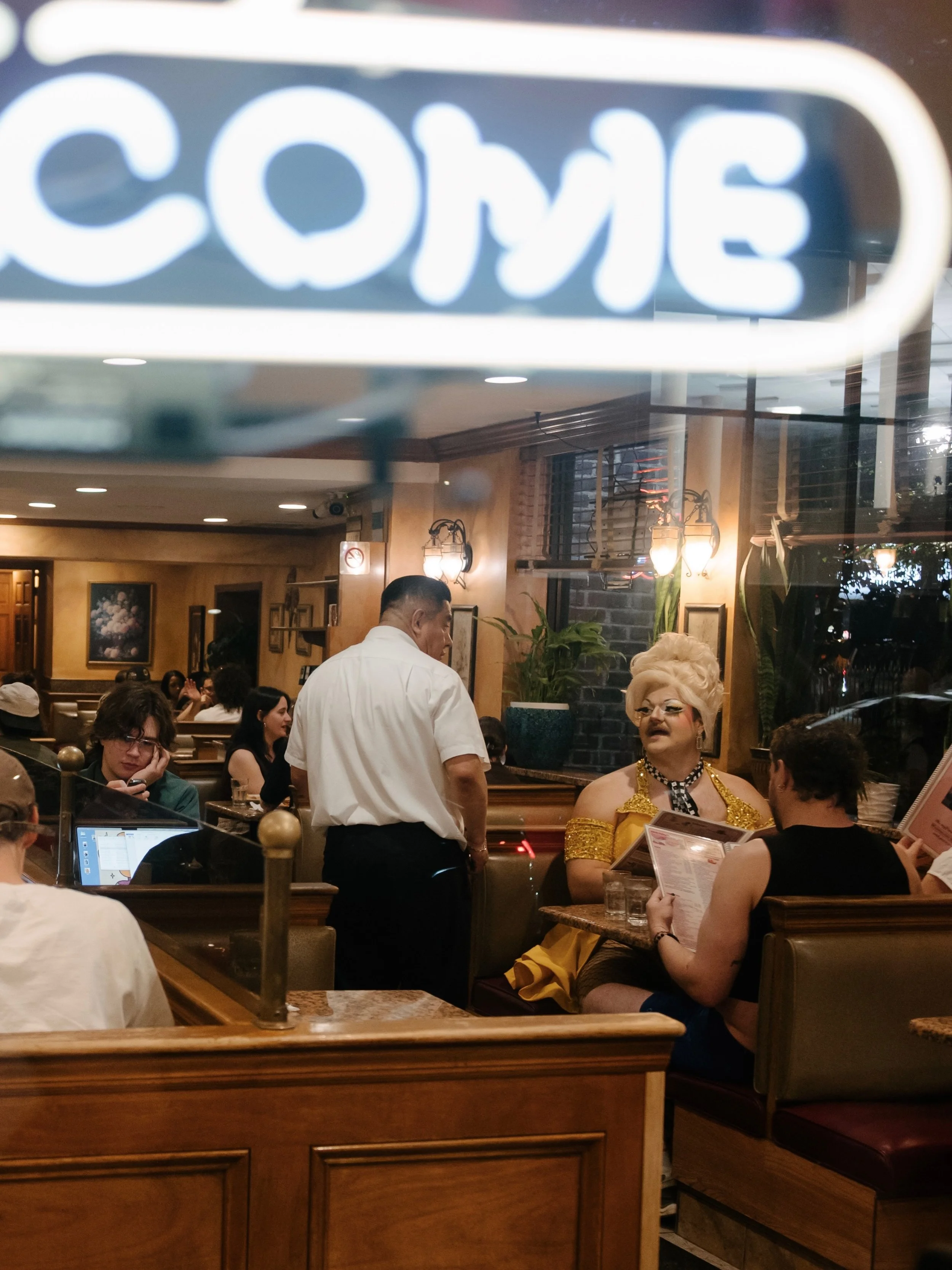 welcome 
[diner after drag march, 2026]

sometimes the moment I see doesn&rsquo;t match the lens I&rsquo;m working with; sometimes I don&rsquo;t zero in on the spark of a scene that caught my eye until later; sometimes there&rsquo;s more than one ima