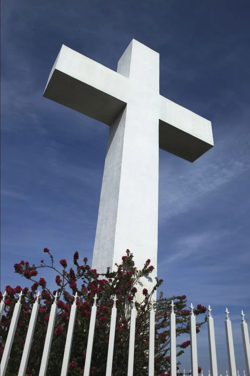 Big white cross with flowers at the bottom