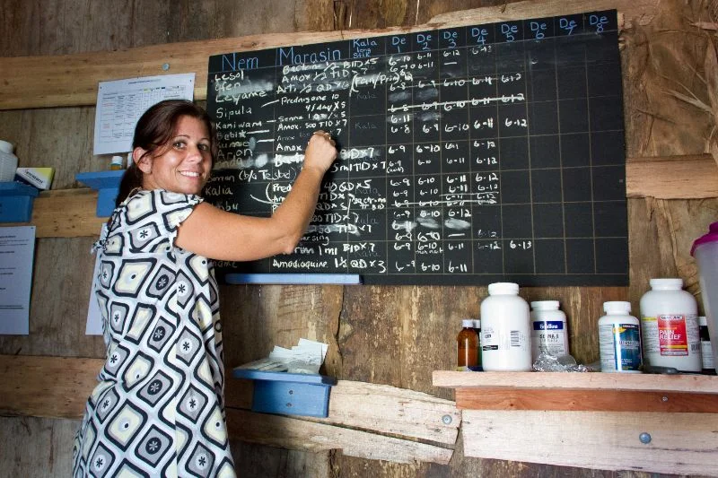 Susan Kopf writing on chalkboard in the clinic