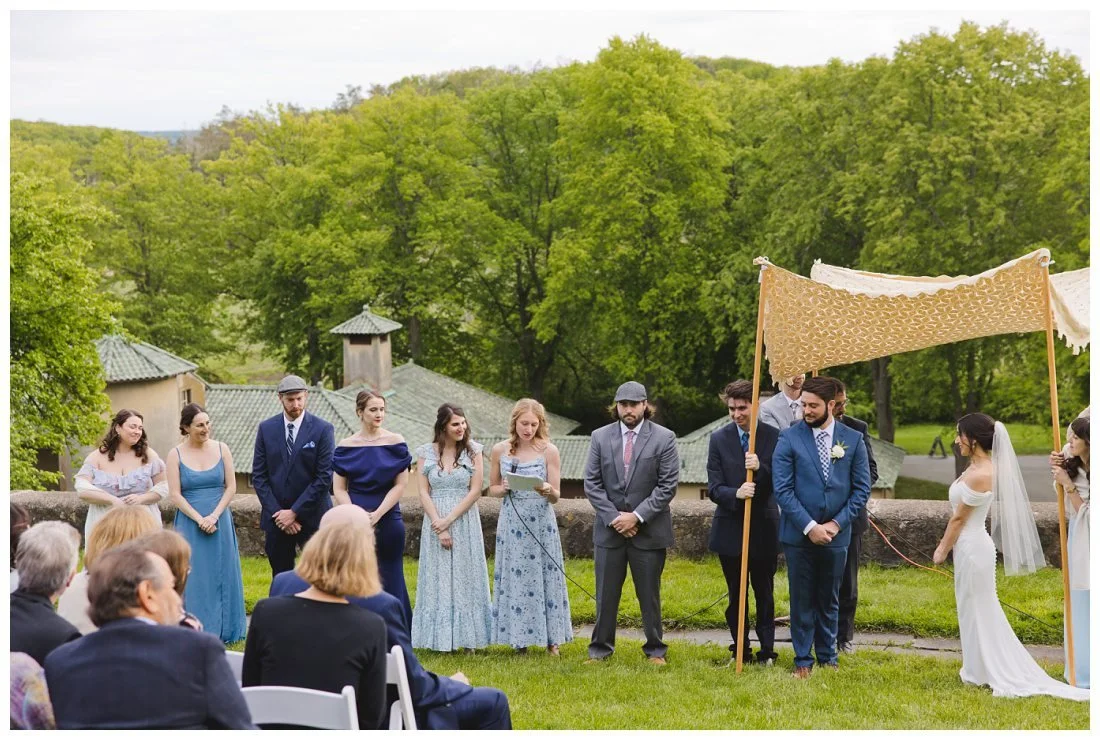 the wedding party reads the traditional seven jewish blessings of wedding ceremony