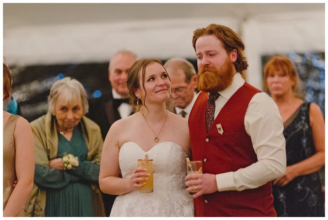 bride looks at groom as he has a tearful moment during best man's wedding toast