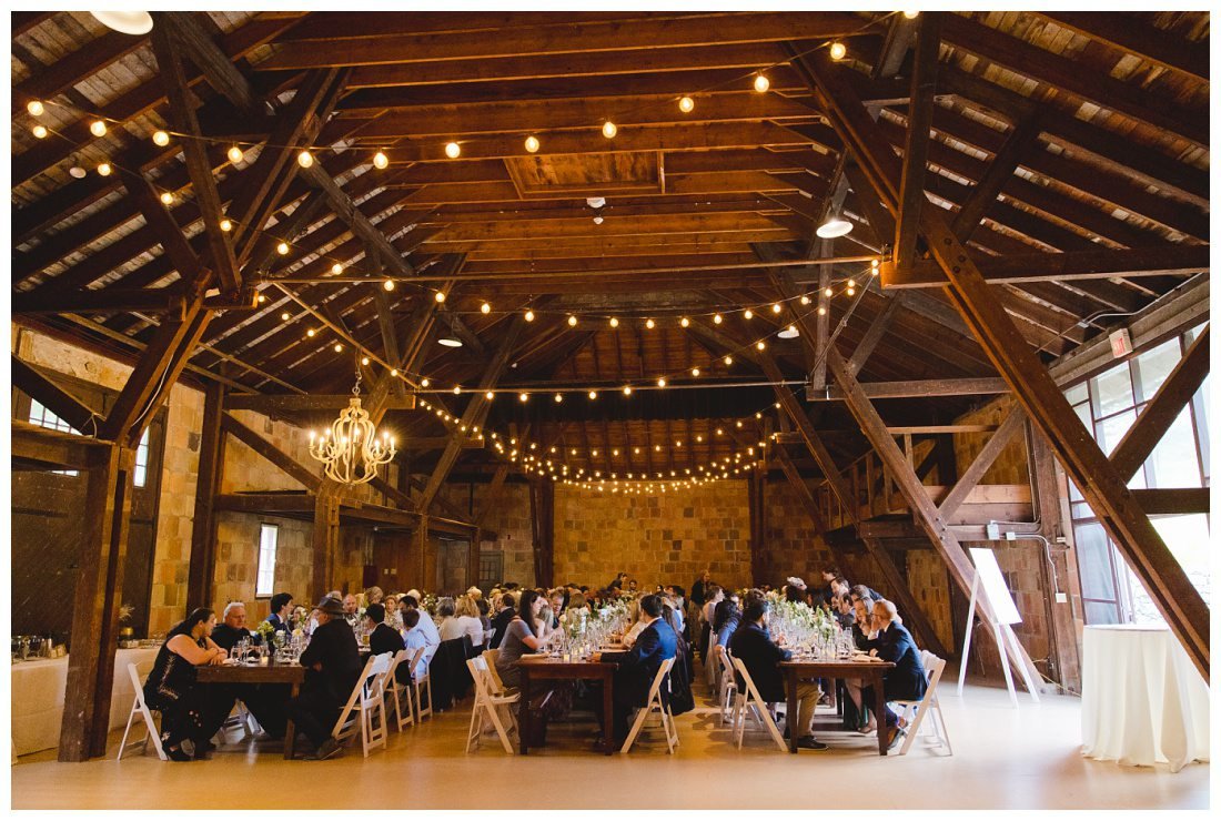 wide angle photo of the barn at crane estate with all the guests seated ready for dinner