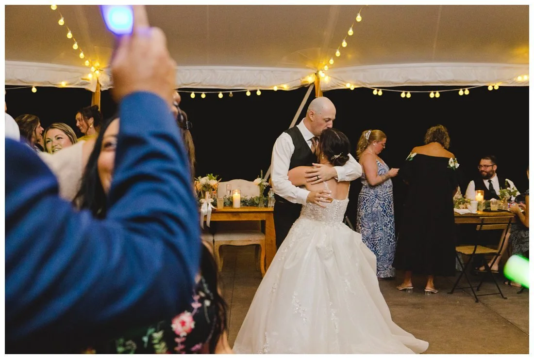 bride and groom hug and kiss on the dance floor
