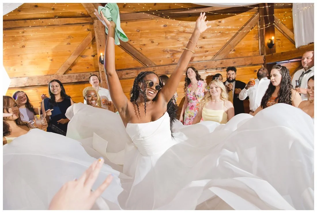 bride's friends surround her and make her dress into a billowing fabric around her on the dance floor