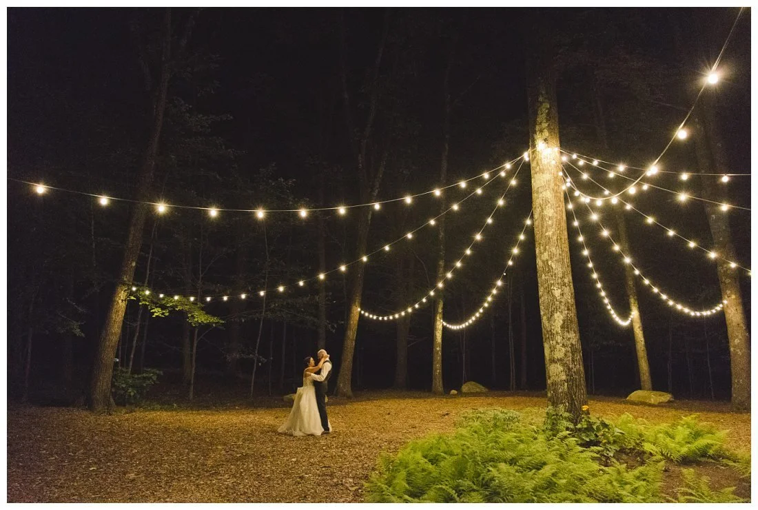 wedding couple under the cafe lights in the woodland gardens at night at uncanoounuc mountain