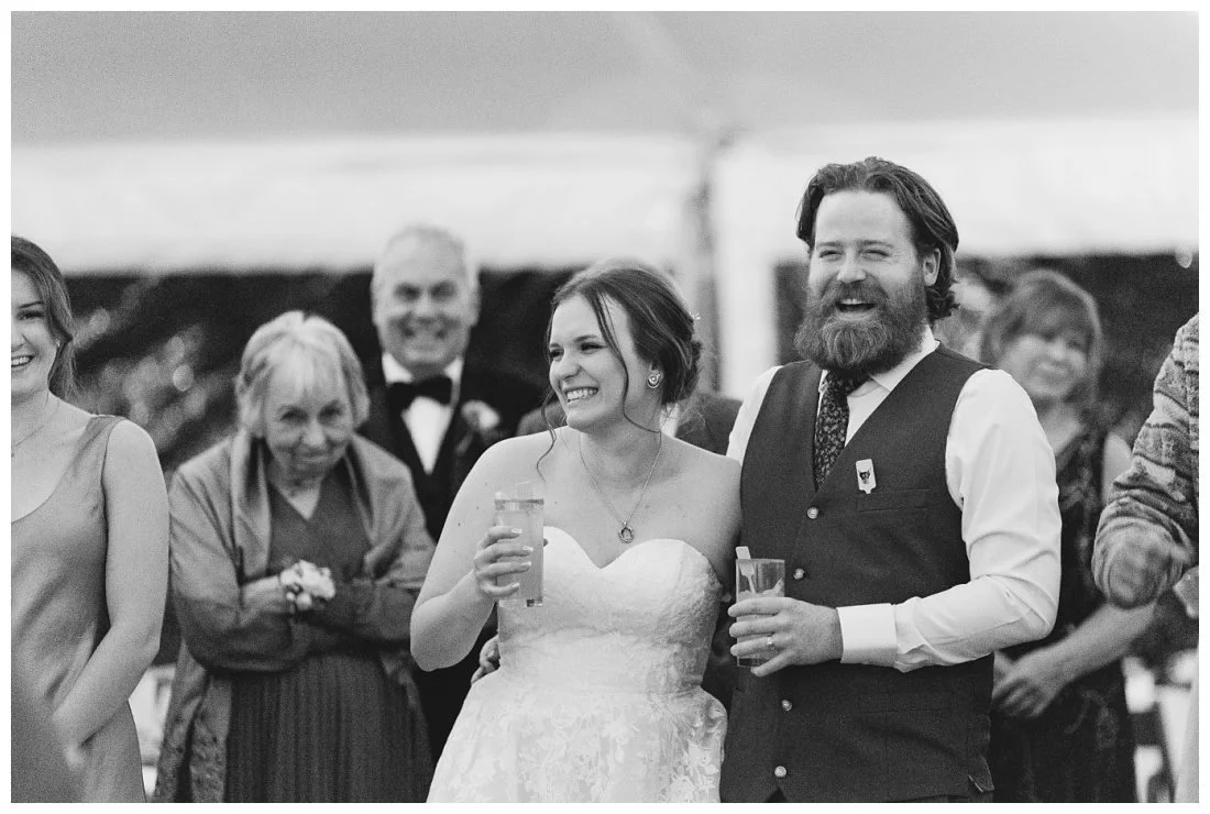 black and white photo of couple laughing during toast