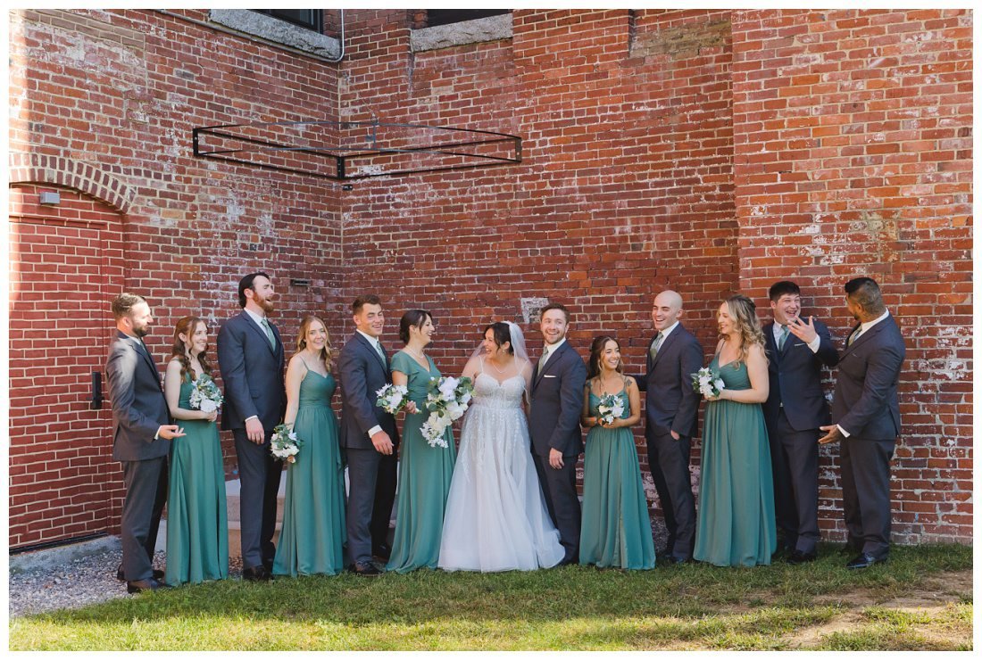 wedding party photos outside the venues at the factory with exposed brick in the courtyard