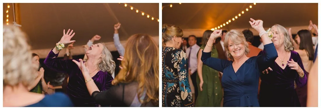 moms of bride and groom dance with their hands up at wedding reception