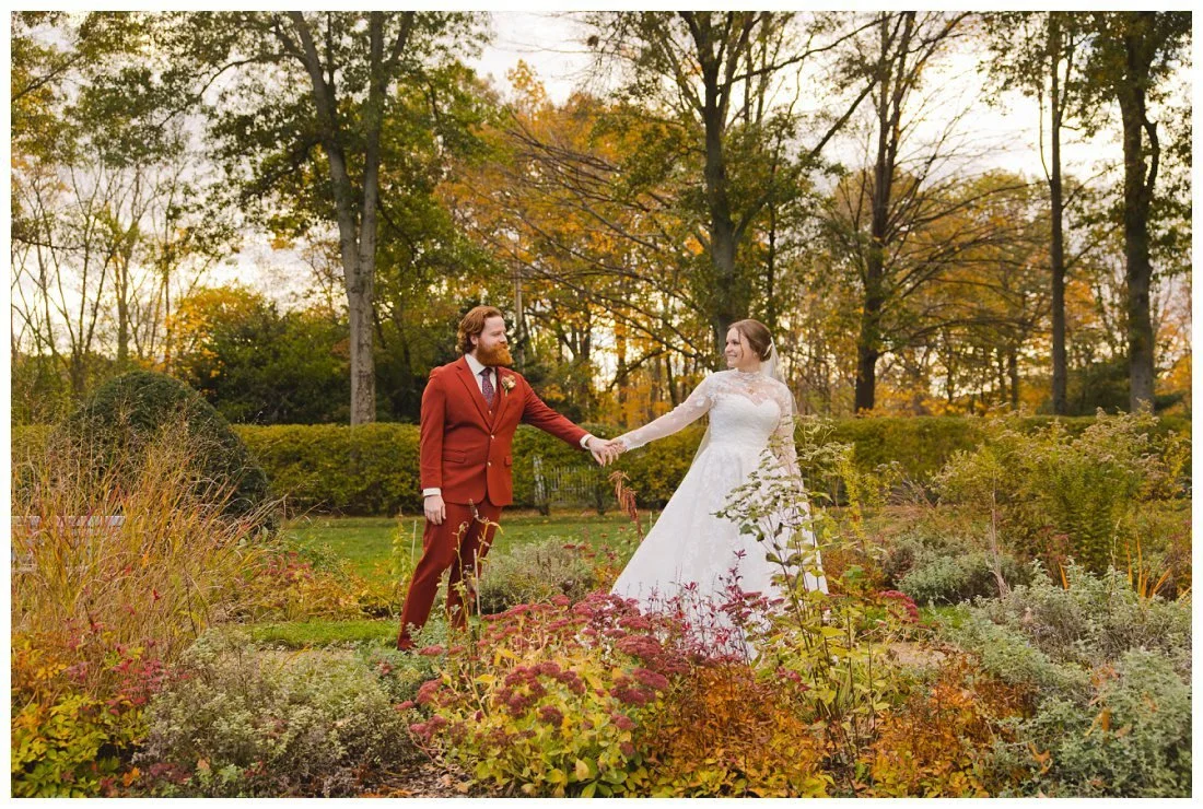bride leads groom to the side during wedding photos at glen magna farms