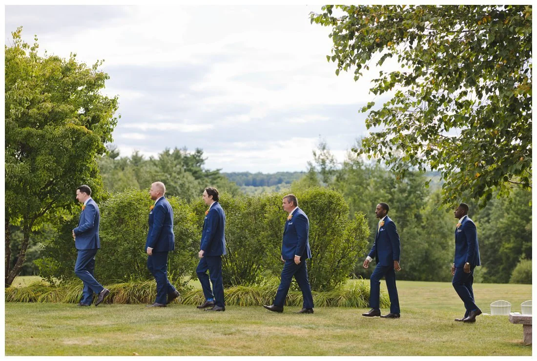 groom and groomsmen walk up to the wedding ceremony in the mountains