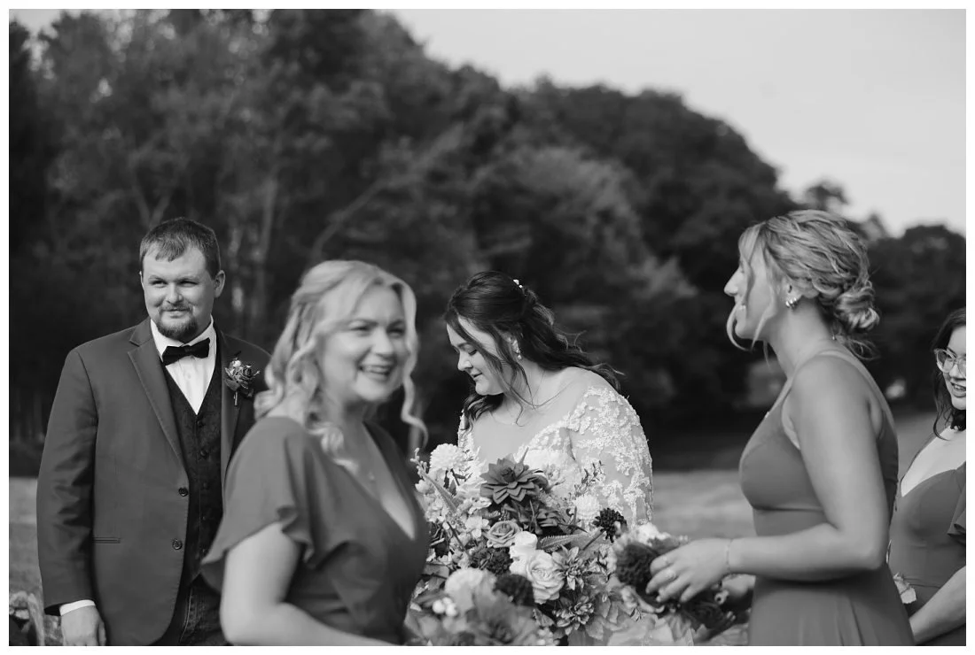 black and white photo of wedding party congregating after ceremony