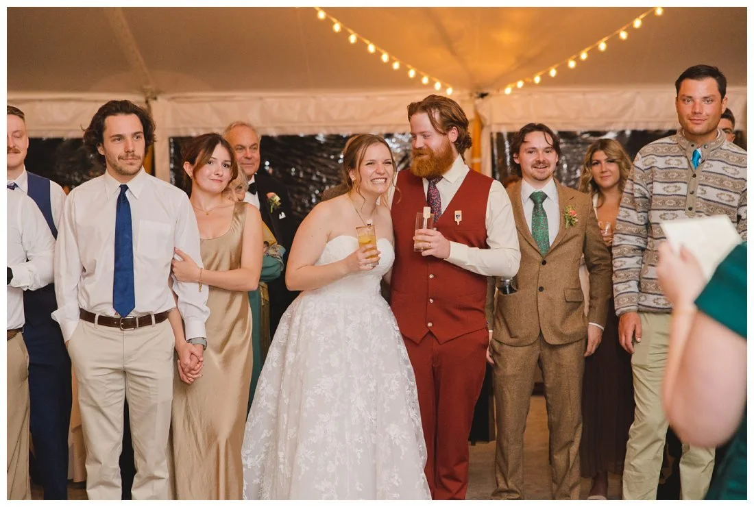 emma laughs while andrew smiles and looks at her during wedding toast