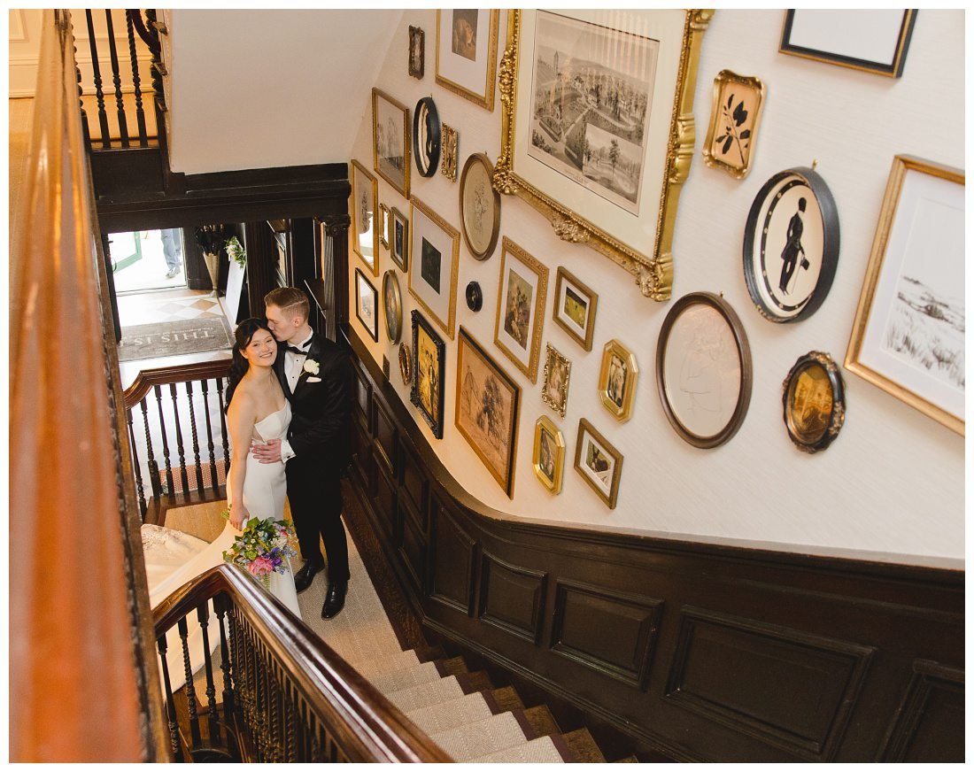 bride and groom kiss on the grand staircase