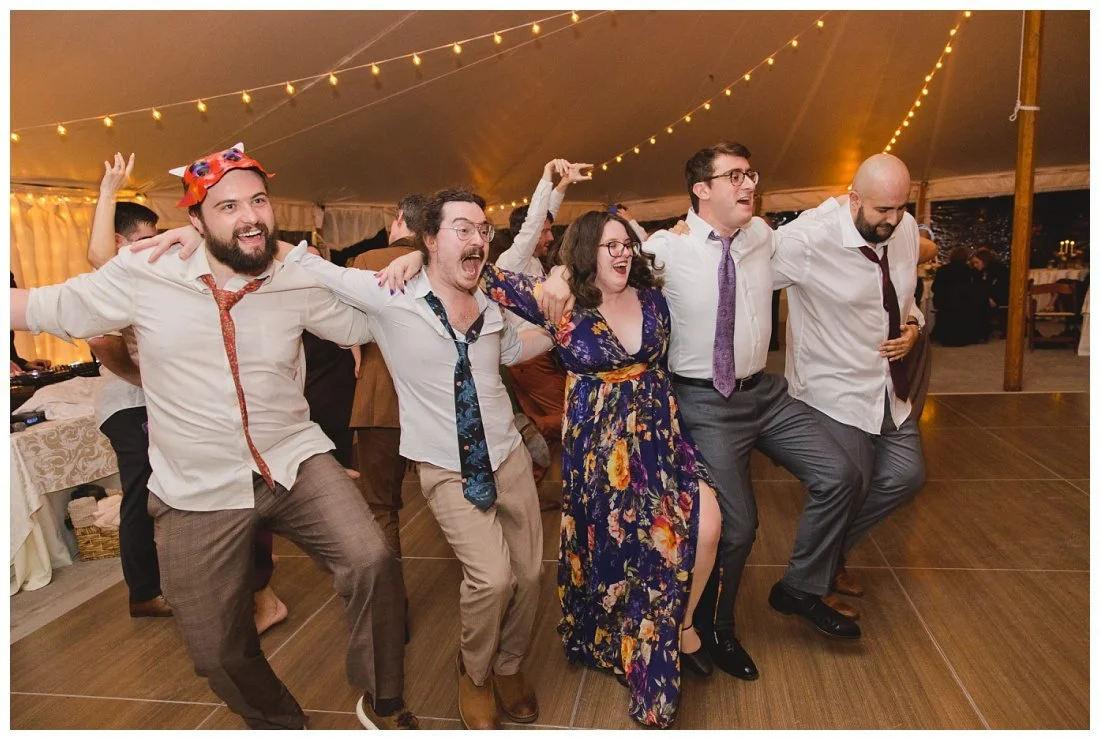 wedding guests form dance lines and do kicks at reception
